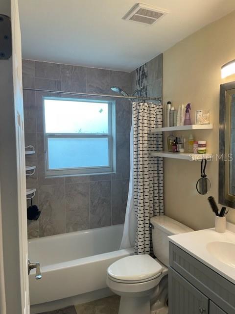 full bathroom with toilet, vanity, and shower / bathtub combination with curtain