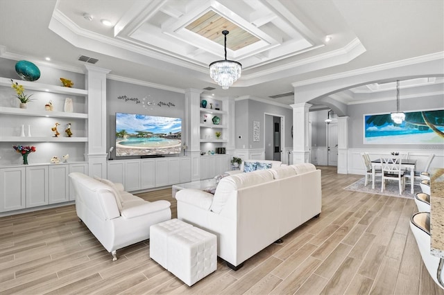 living area featuring arched walkways, built in shelves, a raised ceiling, and visible vents