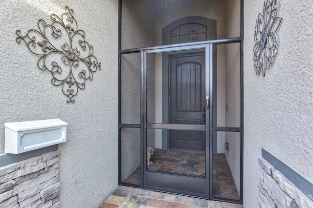 entrance to property with stucco siding