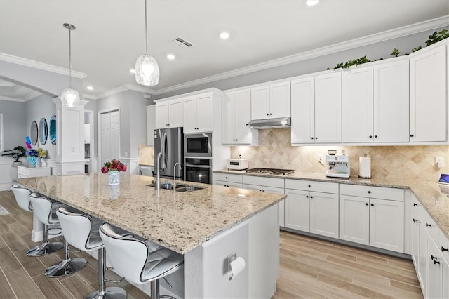 kitchen featuring visible vents, arched walkways, stainless steel appliances, wood finish floors, and under cabinet range hood