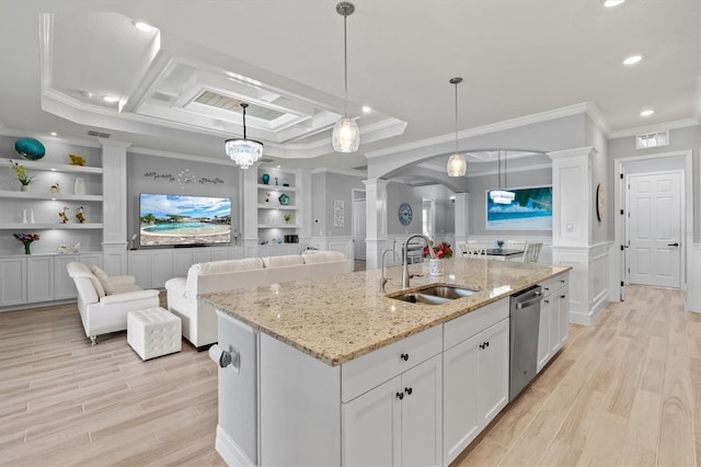 kitchen with built in shelves, arched walkways, a sink, light wood-type flooring, and dishwasher