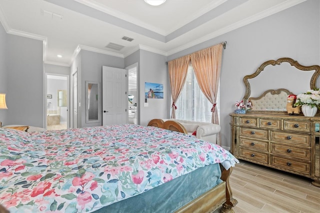 bedroom featuring wood finish floors, visible vents, crown molding, and ensuite bath