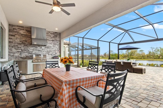 view of patio / terrace with glass enclosure, an outdoor kitchen, a grill, and a water view