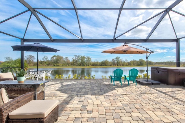 view of patio with glass enclosure, a water view, and a hot tub