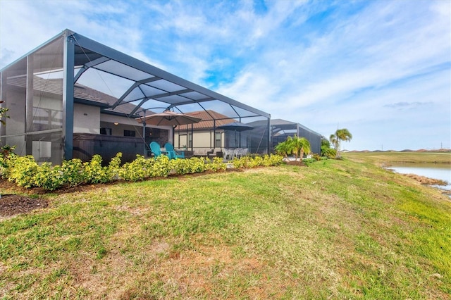 view of yard with glass enclosure and a water view