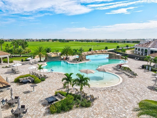 pool with grilling area and a patio area