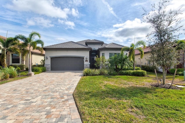 view of front of home with an attached garage, stone siding, decorative driveway, stucco siding, and a front lawn