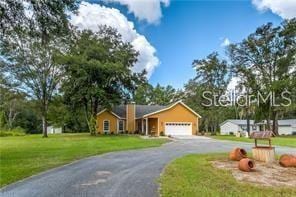 ranch-style home with a garage and a front yard