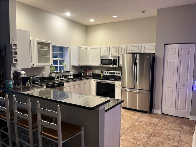 kitchen featuring white cabinetry, sink, stainless steel appliances, and kitchen peninsula