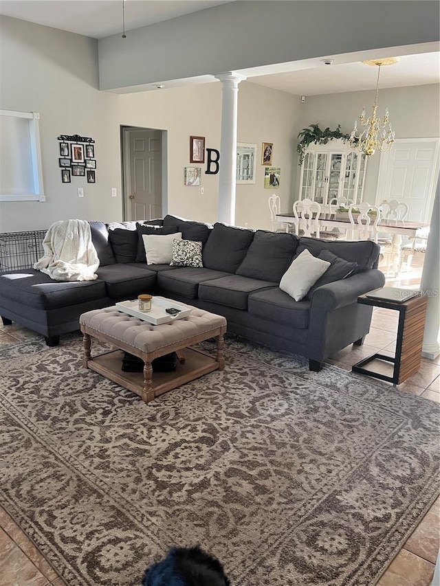 living room featuring a chandelier, decorative columns, and light tile patterned floors