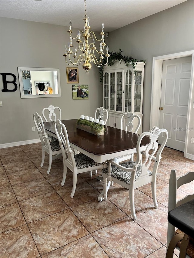 tiled dining room with a textured ceiling and a chandelier