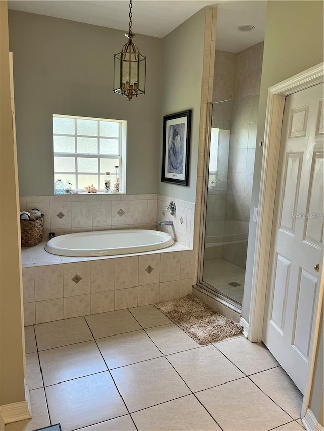 bathroom with tile patterned flooring, independent shower and bath, and an inviting chandelier