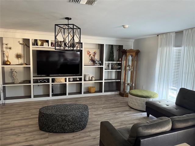 living room featuring crown molding, a chandelier, and hardwood / wood-style flooring