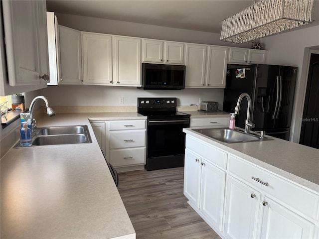 kitchen with sink, black appliances, and white cabinets