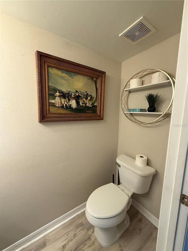 bathroom featuring hardwood / wood-style flooring and toilet