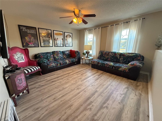 living room with hardwood / wood-style flooring, ceiling fan, and a textured ceiling