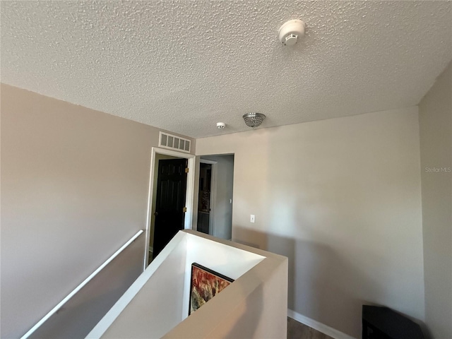 hall featuring a textured ceiling