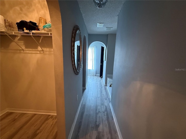 hall featuring hardwood / wood-style floors and a textured ceiling