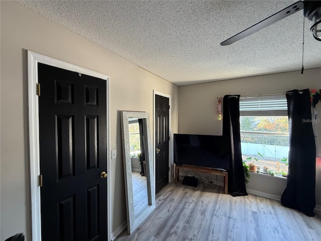 entryway featuring ceiling fan, light hardwood / wood-style floors, and a textured ceiling