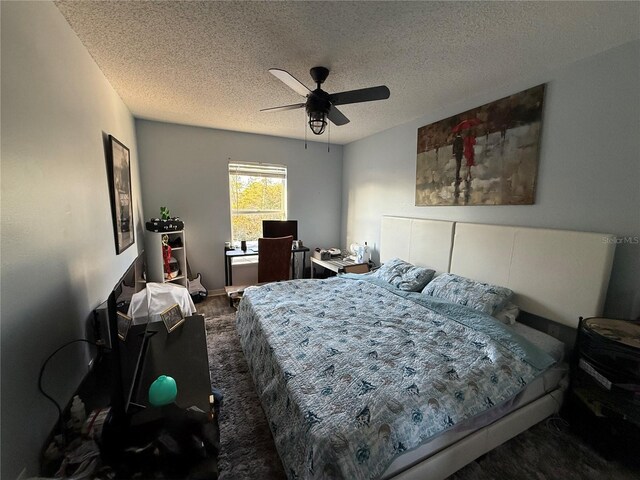 bedroom featuring ceiling fan, dark wood-type flooring, and a textured ceiling