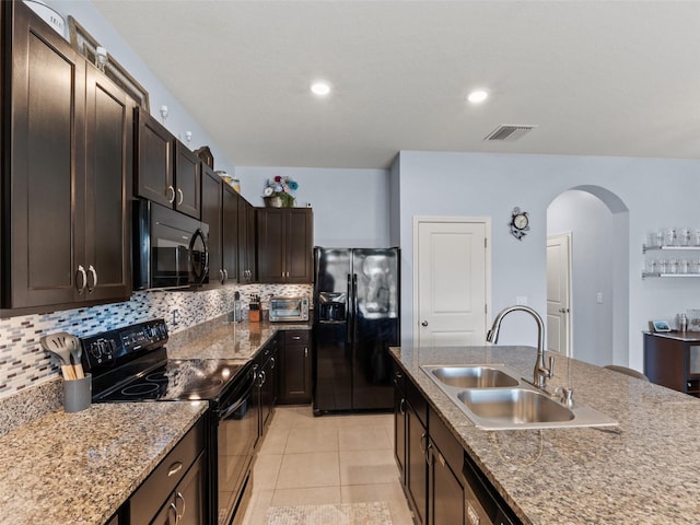 kitchen featuring backsplash, dark brown cabinetry, sink, and black appliances