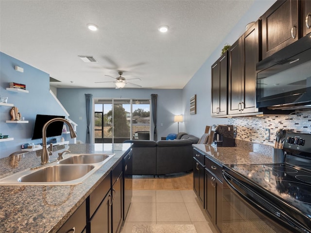 kitchen featuring tasteful backsplash, sink, light tile patterned floors, dark brown cabinetry, and black appliances