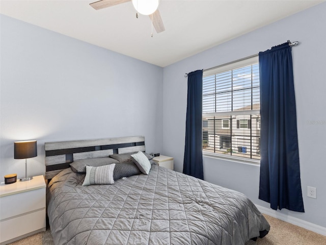 carpeted bedroom with multiple windows, baseboards, and ceiling fan