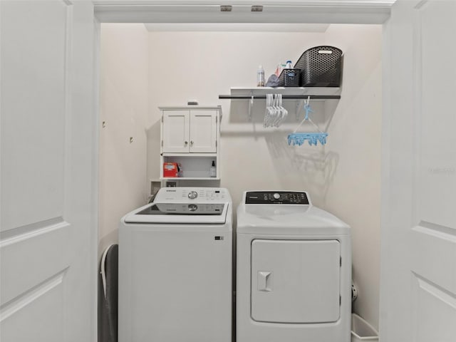 washroom with washing machine and dryer and cabinet space