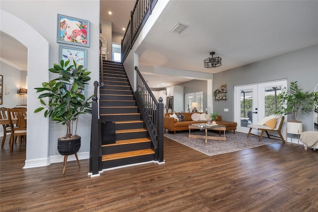 stairs with hardwood / wood-style floors, french doors, and a high ceiling