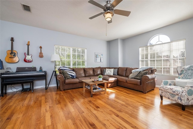 living room with a wealth of natural light, light hardwood / wood-style flooring, and ceiling fan