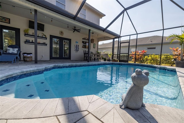 view of swimming pool with french doors, a patio, ceiling fan, and glass enclosure