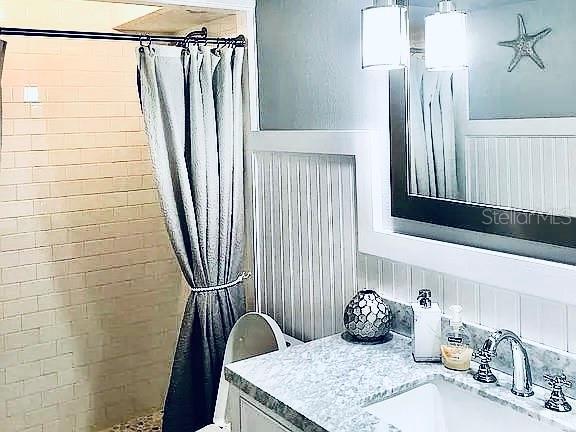 bathroom featuring vanity, toilet, and walk in shower