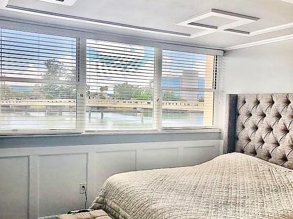 bedroom with crown molding and coffered ceiling