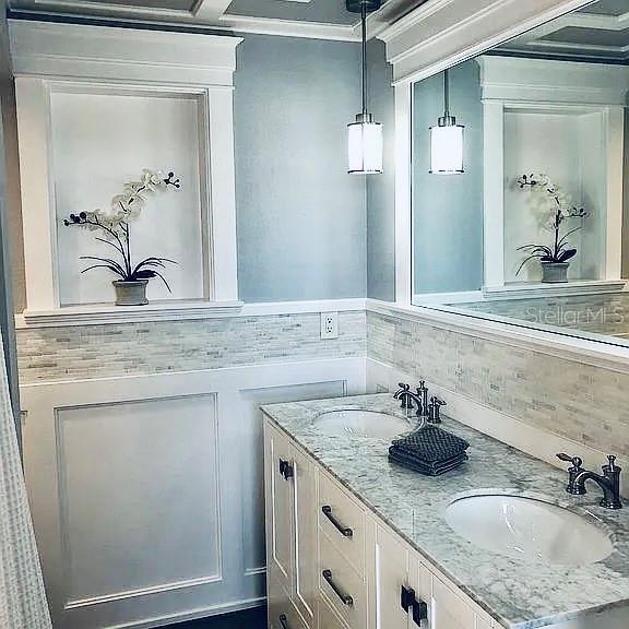 bathroom with ornamental molding, vanity, and decorative backsplash