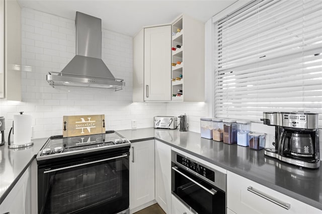 kitchen with white cabinetry, wall chimney exhaust hood, tasteful backsplash, and appliances with stainless steel finishes