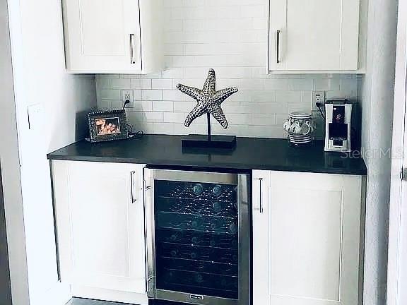 bar with wine cooler and backsplash