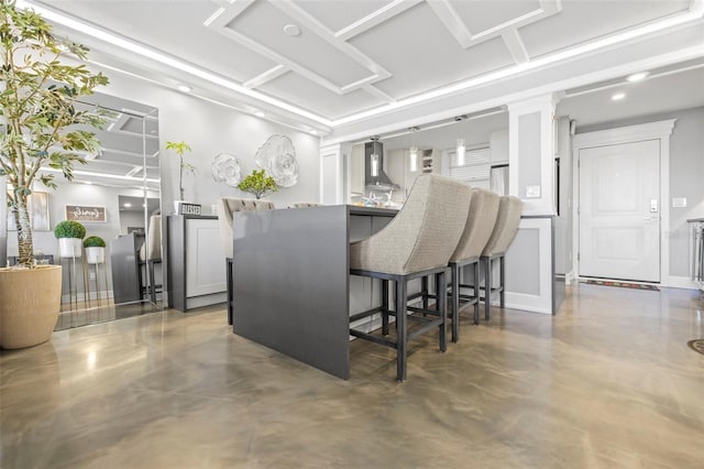 kitchen with wall chimney exhaust hood and concrete floors