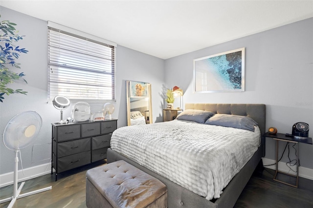 bedroom with dark wood finished floors and baseboards