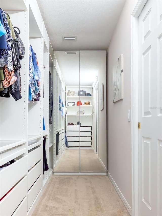 walk in closet featuring light carpet