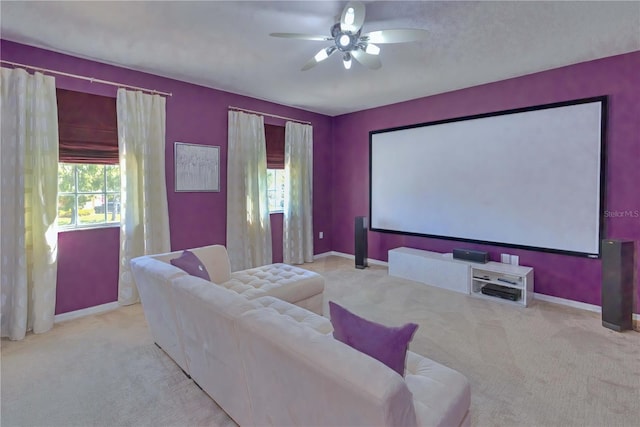 cinema room with ceiling fan, light colored carpet, and a wealth of natural light