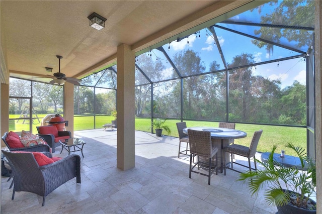 view of patio featuring an outdoor hangout area, ceiling fan, and glass enclosure