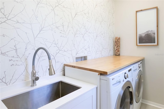 laundry area with washing machine and clothes dryer and sink