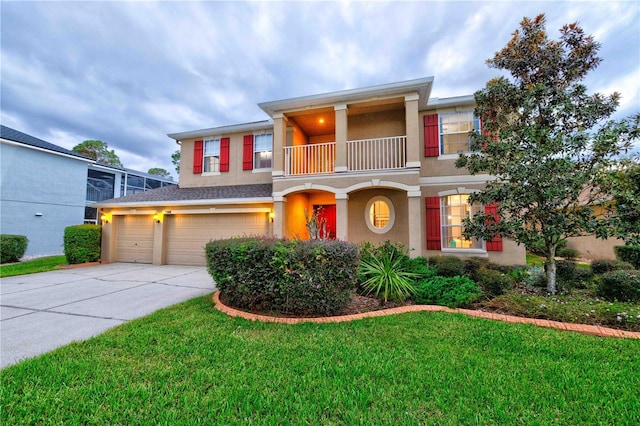 view of front of property featuring a garage, a balcony, and a front lawn