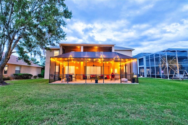 rear view of property featuring a yard, a patio area, and a lanai