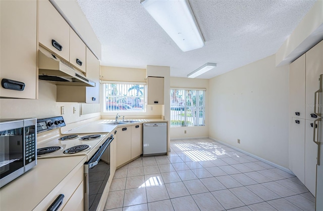 kitchen featuring sink, a textured ceiling, light tile patterned floors, range with electric stovetop, and dishwasher