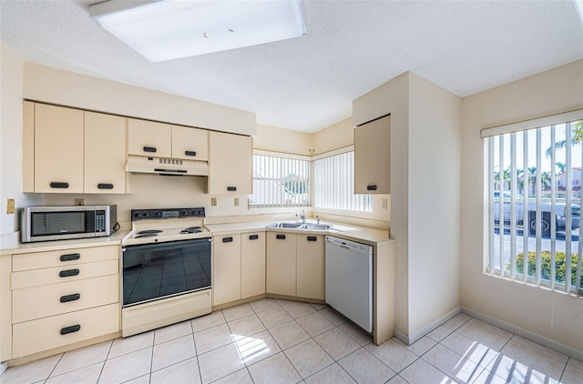 kitchen featuring white appliances, a wealth of natural light, sink, and cream cabinetry