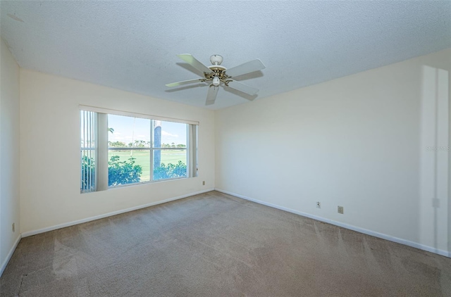 carpeted spare room with ceiling fan and a textured ceiling