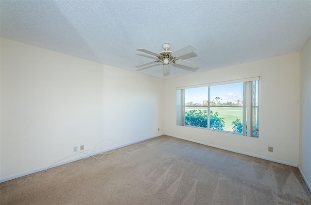 carpeted empty room featuring ceiling fan and a textured ceiling