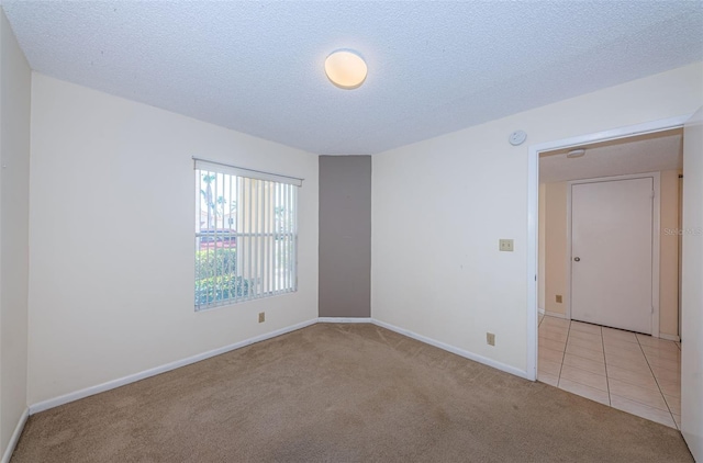 carpeted empty room with a textured ceiling