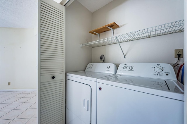 laundry area with light tile patterned flooring and washing machine and clothes dryer